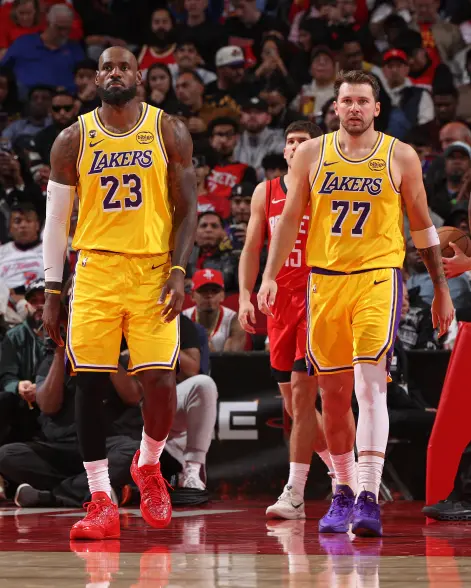 ليبرون جيمس ولوكا دونتشيتش يرتديان زي فريق ليكرز وهما يسيران في الملعب خلال مباراة بين لوس أنجلوس ليكرز وهيوستن روكتس.