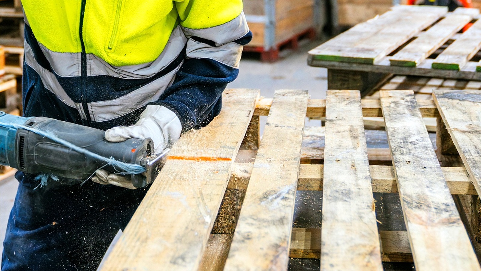 امرأة تستخدم المنصات الخشبية القديمة لإنشاء سطح للفناء الخلفي باستخدام DIY مثير للإعجاب